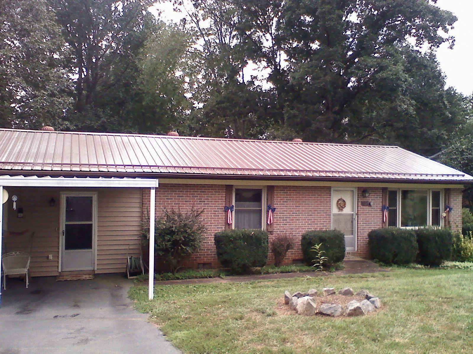 Bronze metal roof and carport on a brick ranch home — Roof Repair work by our crew in Bidwell