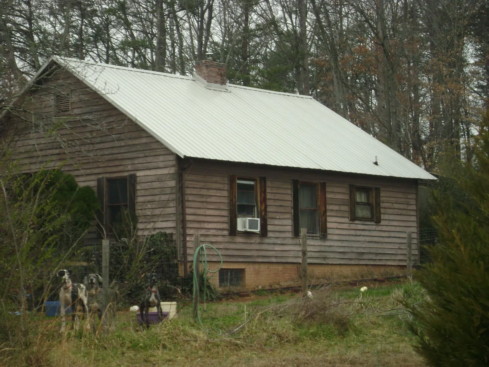 White metal roof on an old wood sided farmhouse, from a Metal Roof Installation job in Bidwell